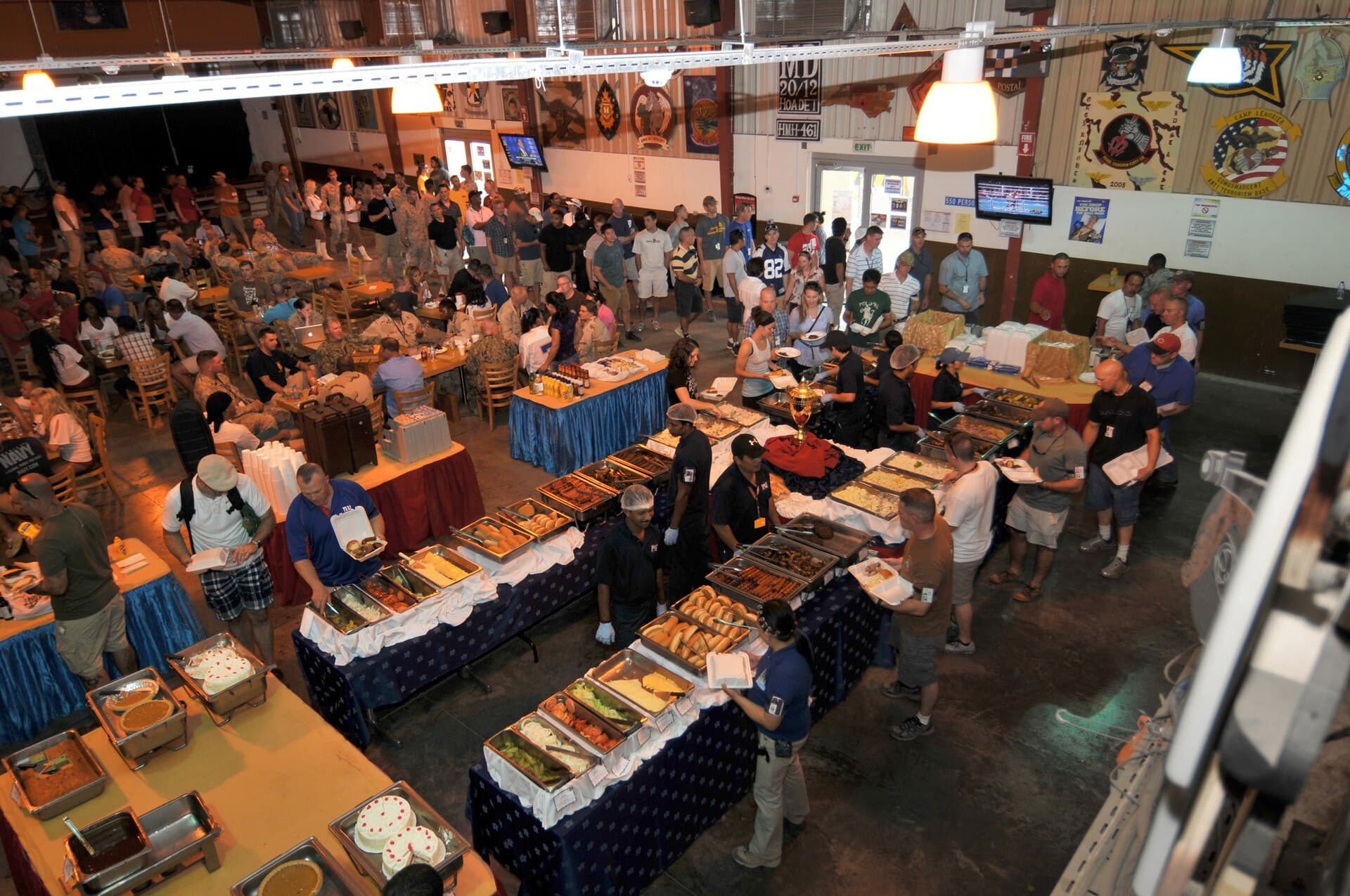 People eating during a tailgate party with food, games, and barbecue competition