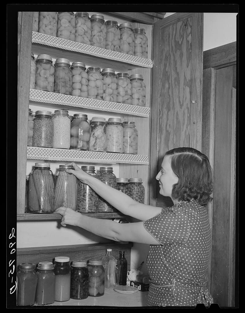 A woman arranging jars of home-canned food at Osage Farms, Missouri in 1939