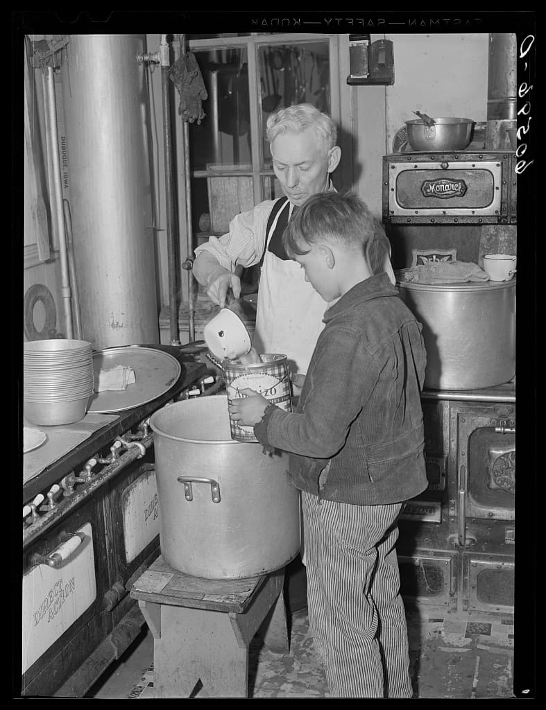 Young boy receiving soup in a city mission kitchen during the Great Depression