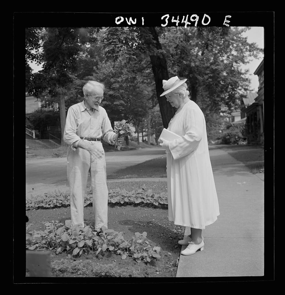 A man showing his wife vegetables from his victory garden in Oswego, New York in 1943